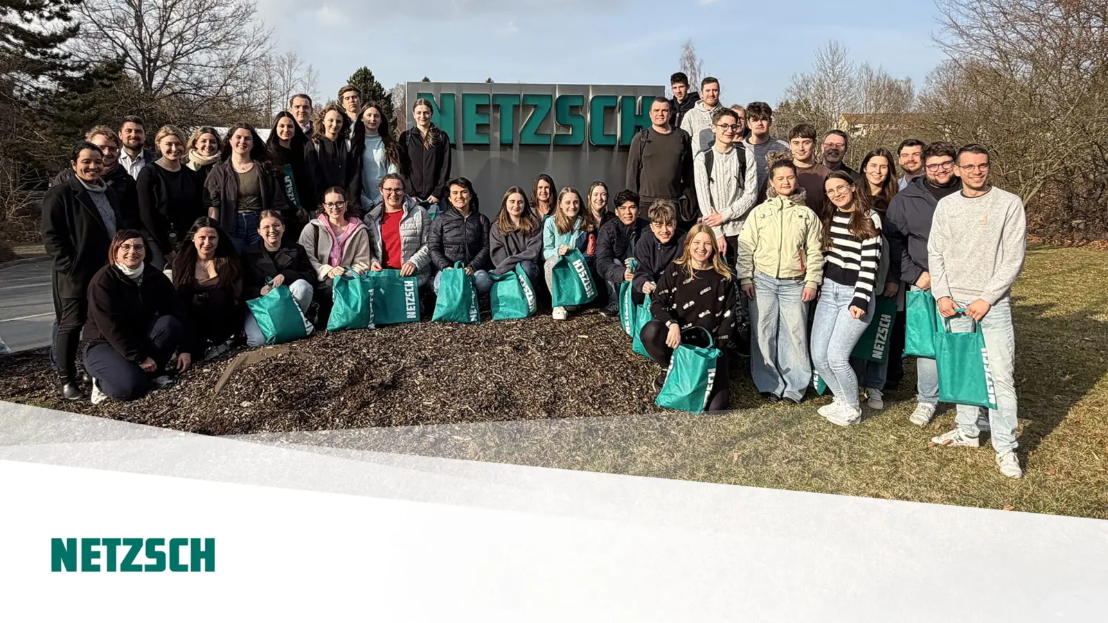 Gruppe von Studierenden vor dem NETZSCH Standort, stolz mit grünen Taschen, Symbol für praxisnahe Ausbildung in Lebensmitteltechnologie.