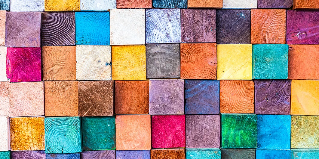Coloridos bloques de madera dispuestos en un vibrante mosaico, mostrando diversas texturas y tonalidades, ideal para aplicaciones y diseños creativos.