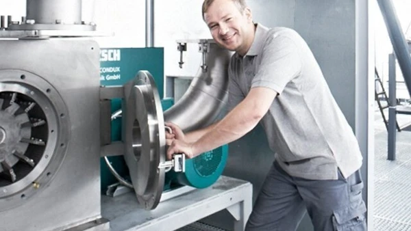 Techniker arbeitet an der NETZSCH Mahlmaschine, optimiert Prozesse für effektives Mahlen in der Industrie.