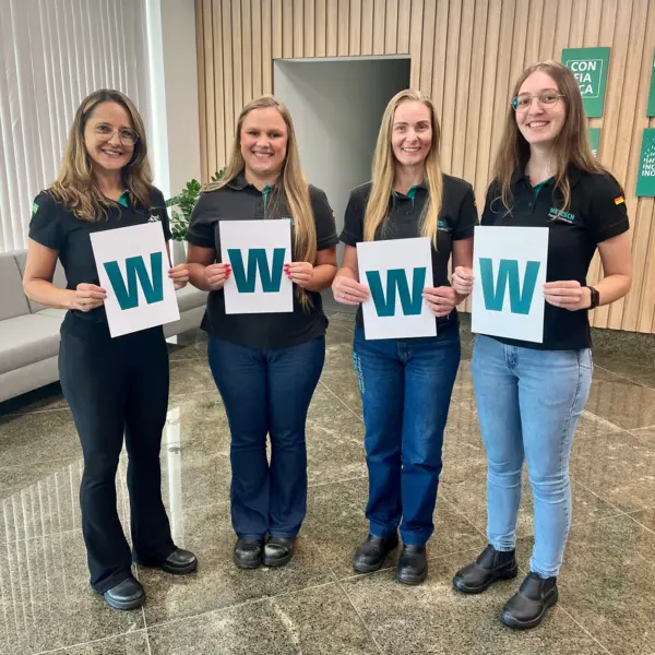 Vier weibliche Kolleginnen von NETZSCH in Brasilien halten Plakate mit dem Buchstaben "W" für den Internationalen Frauentag.