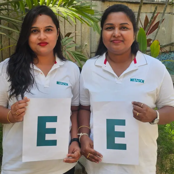 Deux collègues féminines de NETZSCH Inde tiennent les lettres "E" pour une initiative mondiale célébrant la Journée internationale de la femme.