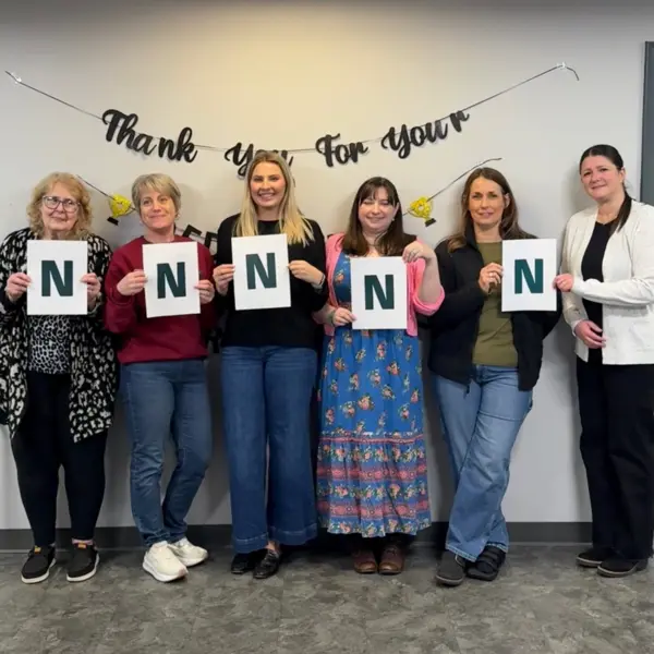 Des collègues féminines de NETZSCH Premier Technologies tiennent des lettres formant le mot "WOMEN", célébrant la Journée internationale de la femme.